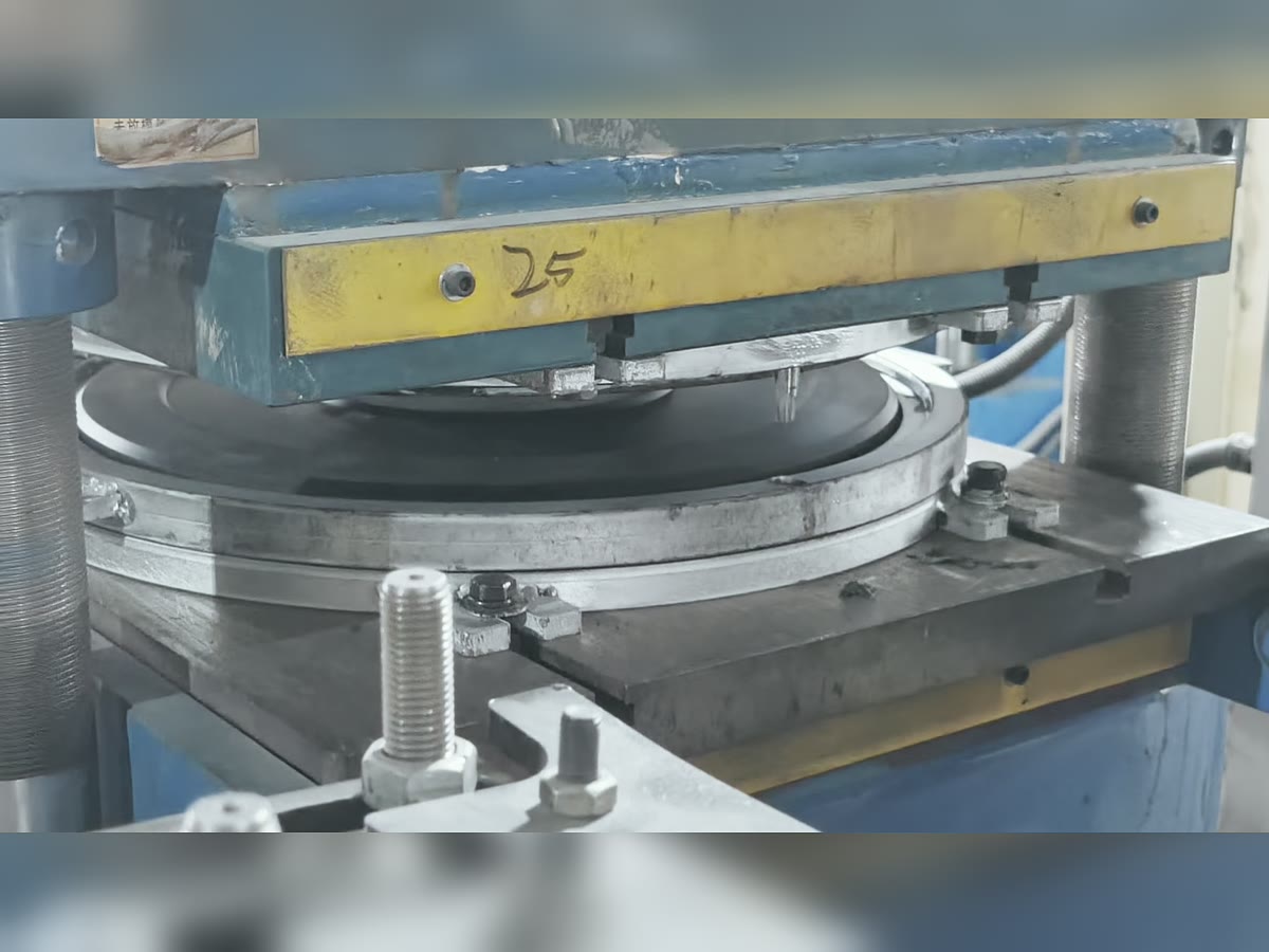 Rubber weight plate mold under press during production