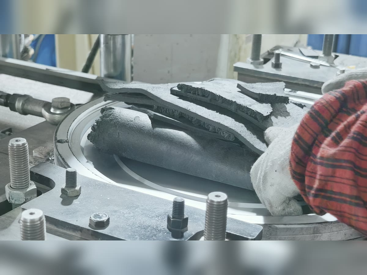 Black rubber material being loaded into a weight plate mold
