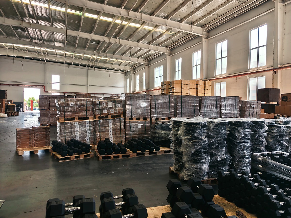 Warehouse stock of black hex dumbbells prepared on pallets for bulk shipment